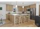 This modern kitchen features an island with seating, stainless steel appliances and hardwood floors at 1200 Carey Ct, Charlotte, NC 28210