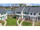 An aerial view shows the townhomes near a lake, with walkways, parking, and landscaping at 130 Water Oak Dr, Pineville, NC 28134