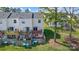 View of a townhome's back deck and yard, with privacy fencing, greenery and recycling bins at 130 Water Oak Dr, Pineville, NC 28134