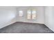 Bedroom with carpet, rear door, windows, and view of fenced-in backyard at 130 Water Oak Dr, Pineville, NC 28134