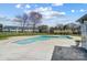 Outdoor community pool with pristine water, surrounded by a concrete patio and landscaping, and neighborhood townhomes at 130 Water Oak Dr, Pineville, NC 28134