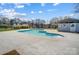 Community pool with a shallow end, surrounded by a concrete patio and landscaping near the clubhouse at 130 Water Oak Dr, Pineville, NC 28134