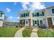 Charming townhome with green shutters and a well-manicured lawn leading to the front door near the lake at 130 Water Oak Dr, Pineville, NC 28134