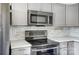 Close-up of kitchen features stainless steel stove and microwave, complemented by chic backsplash and countertops at 130 Water Oak Dr, Pineville, NC 28134