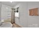 Clean white bathroom with tub shower, featuring horizontally paneled walls and light colored flooring at 1339 Hill St, Albemarle, NC 28001