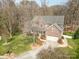 An elevated view of a beautiful brick home surrounded by lush greenery and mature trees on a sunny day at 1347 Lightwood Dr, Matthews, NC 28105