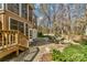 View of a brick patio with outdoor seating, adjacent to a screened-in porch and a wooded backyard area at 1347 Lightwood Dr, Matthews, NC 28105