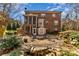 Brick home with a screened-in porch and patio featuring a fire pit and landscaped backyard at 1347 Lightwood Dr, Matthews, NC 28105