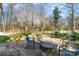 Outdoor patio area with a stone fire pit and seating, surrounded by a wooded area and small water features at 1347 Lightwood Dr, Matthews, NC 28105