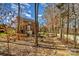 Backyard gravel path lined with stones, leading through a wooded area behind a brick home at 1347 Lightwood Dr, Matthews, NC 28105