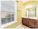 Bright bathroom featuring a vanity with storage, framed mirror, and window offering natural light with blinds at 1347 Lightwood Dr, Matthews, NC 28105