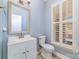 Bathroom featuring a framed mirror, white vanity, and a window with plantation shutters at 1347 Lightwood Dr, Matthews, NC 28105