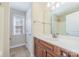 Bathroom featuring a single sink vanity with framed mirror and a shower-tub combo at 1347 Lightwood Dr, Matthews, NC 28105