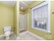 A full bathroom with a toilet, shower, and window providing natural light with blinds at 1347 Lightwood Dr, Matthews, NC 28105