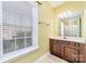 Well-lit bathroom with a vanity, mirror, and a view from the window at 1347 Lightwood Dr, Matthews, NC 28105