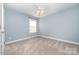 Bedroom featuring neutral carpet, blue painted walls, white trim, and a ceiling fan with lights at 1347 Lightwood Dr, Matthews, NC 28105