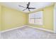 Bedroom featuring yellow walls, neutral carpet, and a ceiling fan at 1347 Lightwood Dr, Matthews, NC 28105