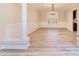 Dining room featuring a large window, white wainscoting, light wood floors, and decorative column at 1347 Lightwood Dr, Matthews, NC 28105