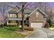 Charming two-story brick home featuring a well-manicured lawn and attached two-car garage at 1347 Lightwood Dr, Matthews, NC 28105