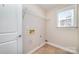 A laundry room featuring white painted walls, shelving, and trim at 1347 Lightwood Dr, Matthews, NC 28105