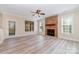 Living room featuring a stone fireplace, light wood flooring, and bright natural light at 1347 Lightwood Dr, Matthews, NC 28105