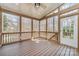 Screened-in porch featuring wood railing, ceiling fan, and natural views at 1347 Lightwood Dr, Matthews, NC 28105