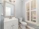 Charming powder room with a white vanity, toilet, and shuttered window at 1347 Lightwood Dr, Matthews, NC 28105