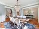 Open dining room featuring hardwood floors, large windows, a modern chandelier, and crown molding at 1355 Wyndmere Hills Ln, Matthews, NC 28105