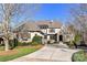 Stunning exterior elevation showcasing a well-manicured lawn and a charming stone and stucco facade at 1355 Wyndmere Hills Ln, Matthews, NC 28105