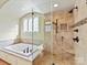 Spa-like main bathroom with a luxurious soaking tub, glass shower, and stone tile accents at 1355 Wyndmere Hills Ln, Matthews, NC 28105