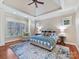 Tranquil primary bedroom suite featuring a tray ceiling, ample natural light, and a sitting area at 1355 Wyndmere Hills Ln, Matthews, NC 28105