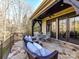 Relaxing covered patio with stone flooring, ceiling fan, comfortable seating, and elegant dining area at 1355 Wyndmere Hills Ln, Matthews, NC 28105