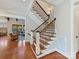 Elegant staircase with wood treads, white risers, and wrought iron railings, leading to an open living area at 1355 Wyndmere Hills Ln, Matthews, NC 28105