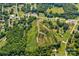 This aerial view captures a sprawling lot, encompassed by flourishing trees and bordering a tranquil road at 1414 S Post Rd, Shelby, NC 28152