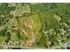 This aerial view showcases a verdant lot, surrounded by lush trees and bordering a peaceful road at 1414 S Post Rd, Shelby, NC 28152