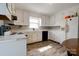 Bright kitchen featuring white cabinets, and a sink, with wood-look floors at 1414 S Post Rd, Shelby, NC 28152