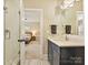 Modern bathroom with dual vanity, marble countertop, and a walk-in shower, leading to bedroom at 144 Morgan Bluff Rd, Mooresville, NC 28117