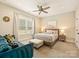 Cozy bedroom showcasing a plush blue sofa, ceiling fan, and window with natural light at 144 Morgan Bluff Rd, Mooresville, NC 28117