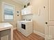 Well-lit laundry room with washer, dryer, and storage cabinets at 144 Morgan Bluff Rd, Mooresville, NC 28117