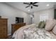 Comfortable bedroom featuring a ceiling fan, dresser, and a cozy bed with decorative pillows at 150 Shields Dr, Lincolnton, NC 28092