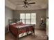 Serene main bedroom with tray ceilings, a fan, and natural light from the window at 1640 Winthrop Ln, Monroe, NC 28110