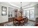 Open concept dining room featuring a wood table set, plantation shutters and classic chandelier lighting at 17201 Royal Court Dr, Davidson, NC 28036