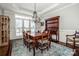 Formal dining room with dark wood furniture, statement lighting, and large windows with plantation shutters at 17201 Royal Court Dr, Davidson, NC 28036