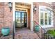 Close up of the front door with brick stairs, iron railings, and detailed lighting fixtures at 17201 Royal Court Dr, Davidson, NC 28036