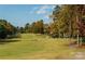 Beautiful golf course view with mature trees, manicured fairways, and a winding path on a sunny day at 17201 Royal Court Dr, Davidson, NC 28036