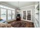 Living room with abundant light, plantation shutters, hardwood flooring and french doors at 17201 Royal Court Dr, Davidson, NC 28036