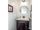 Cozy powder room features a round mirror and picture frame molding at 17201 Royal Court Dr, Davidson, NC 28036