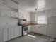 Well-lit kitchen featuring white cabinets, modern stainless steel appliances, and tile flooring at 2210 Milton Rd, Charlotte, NC 28215