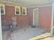 Patio featuring brick wall, windows, an exterior door, and a concrete pad at 2210 Milton Rd, Charlotte, NC 28215