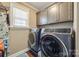 A fully furnished laundry room with modern washer and dryer appliances and overhead storage at 2375 Ellison Cir, Lancaster, SC 29720